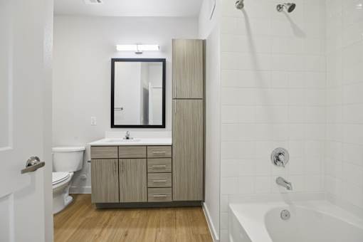 Bathroom with tall linen tower and white tile tub at Matador Apartments, Texas, 78745