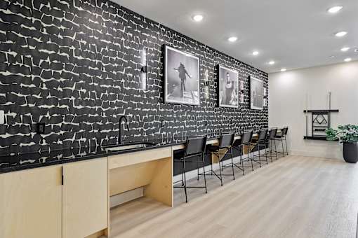 A black and white photo of a room with a brick wall and a row of chairs.