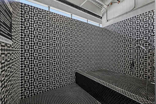 A black and white tiled room with a bench.