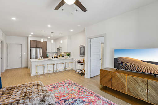 A modern living room with a flat screen TV and a bar area. at ThreeTwenty at the Vybe Apartments, Kyle, 78640