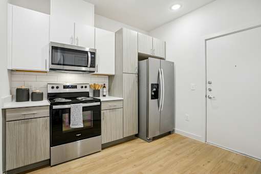 Kitchen with stainless refrigerator and white upper cabinets at Matador Apartments, Texas