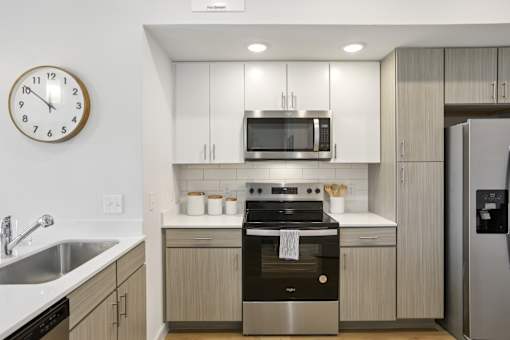 A modern kitchen with a stainless steel oven and a clock on the wall. at Park South Apartments, Austin, TX, 78748