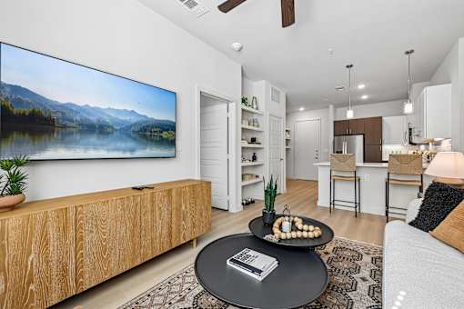 A modern living room with a large wooden entertainment center and a flat screen TV mounted on the wall.