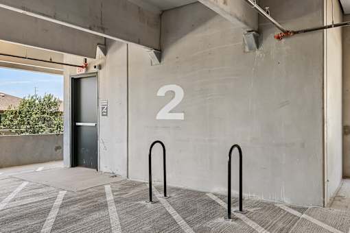 A concrete wall with a number 2 on it and a black door.
