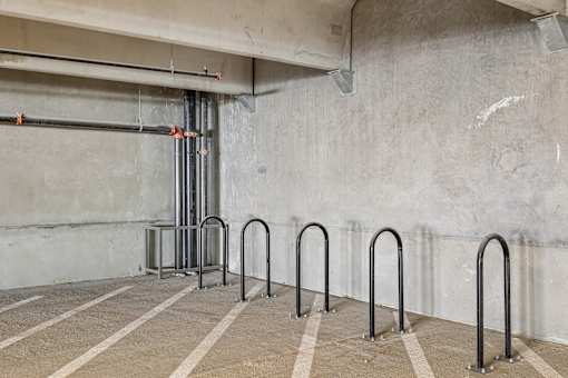A parking garage with concrete walls and striped concrete floors.