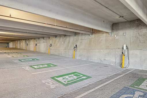 A parking garage with green and white parking spots.