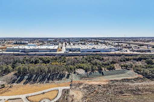 A large industrial area with multiple buildings and a clear blue sky above. at ThreeTwenty at the Vybe Apartments, Kyle, TX