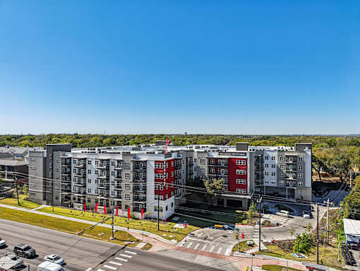 Modern apartment complex exterior with green spaces at Matador Apartments, Austin, TX