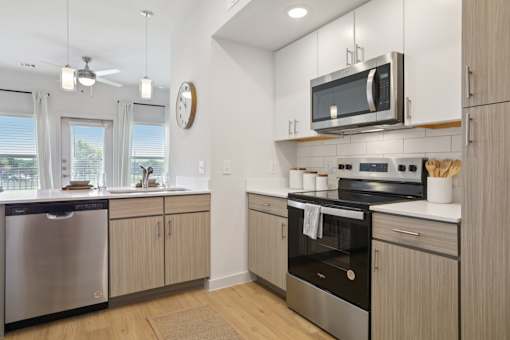 A modern kitchen with stainless steel appliances and wooden cabinets. at Park South Apartments, Austin, 78748