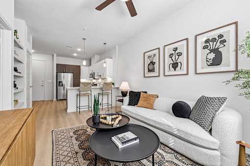 A living room with a white couch and a coffee table with a book on it.