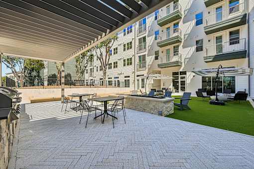 A patio with a table and chairs is surrounded by a building.