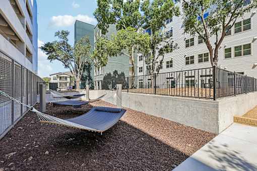 A modern outdoor area with hammocks and a metal fence.