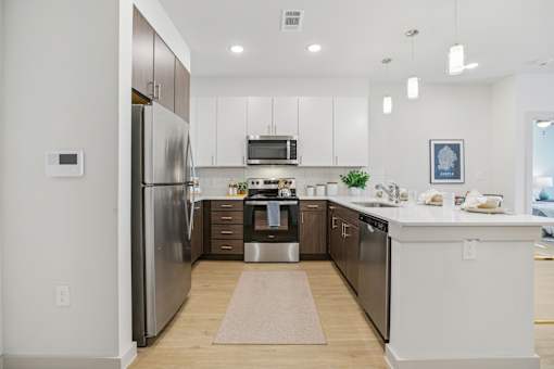 A modern kitchen with a refrigerator, microwave, and oven. at ThreeTwenty at the Vybe Apartments, Texas, 78640