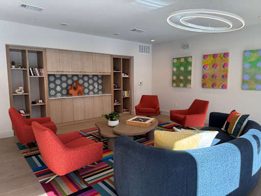 A room with a long wooden bookshelf and a grey patterned tile backsplash at ThreeTwenty at the Vybe Apartments, Kyle, TX