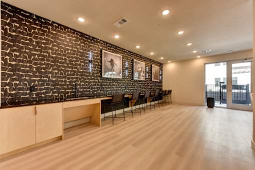 A room with a black brick wall and wooden flooring.