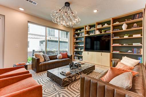A living room with a brown couch, a coffee table, and a bookshelf.