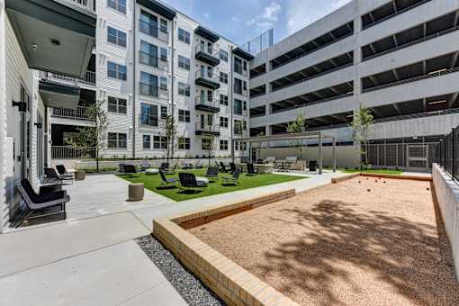 A sandy play area in front of a white building.