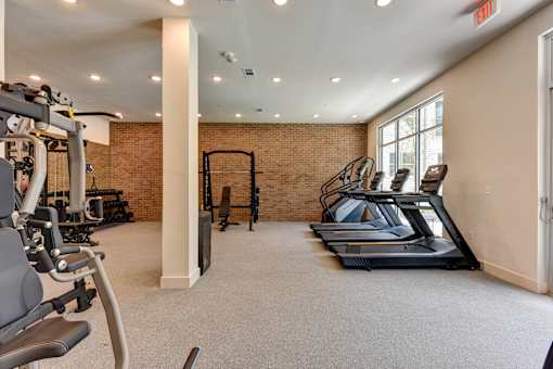 A gym with treadmills, weights, and exercise equipment.