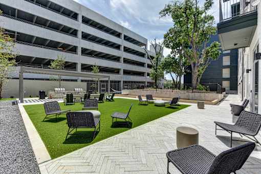 A patio area with black chairs and tables.