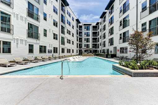 A swimming pool in front of a white building.