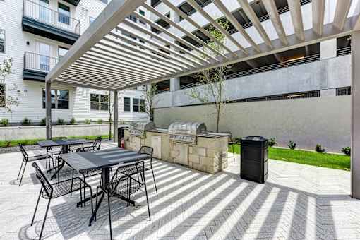 A patio with a table and chairs under a pergola.