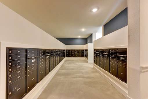 A long hallway with black lockers on both sides.