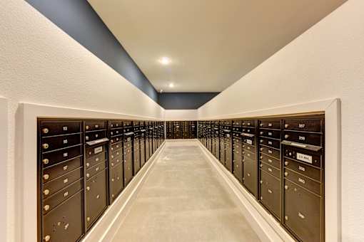 A long hallway with a series of black mailboxes on either side.