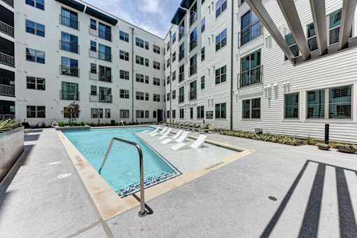 A swimming pool is located on the rooftop of a building.