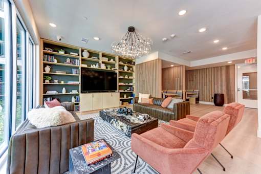 A living room with a brown couch, a coffee table, and a chandelier.