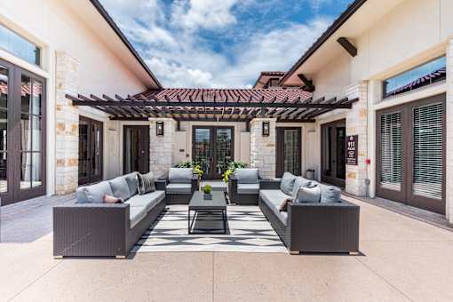 a patio with couches and a coffee table under a pergola at Avery Ranch, Texas