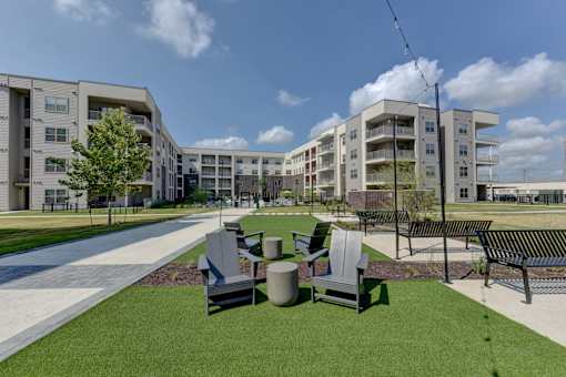 Community courtyard with seating and green space at Cantarra Apartments, Manor, TX