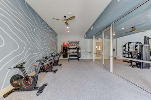 Fitness center with spin bikes and equipment at Cantarra Apartments, Manor, TX