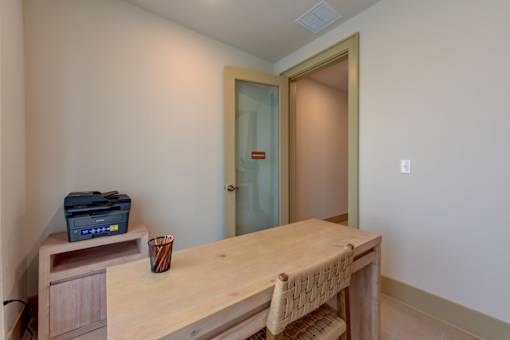 Home office with wooden desk and printer at Cantarra Apartments, Texas