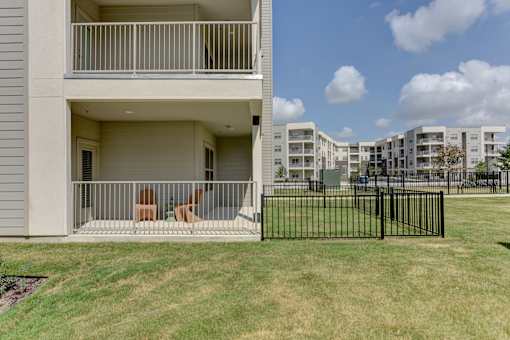 Ground floor covered patio with metal railing at Cantarra Apartments, Manor, TX 78653