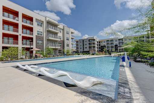 Resort style pool with sun shelf and lounge chairs at Cantarra Apartments, Texas, 78653