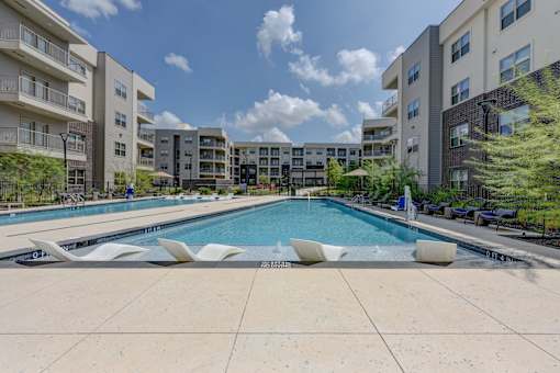 Resort style pool with sun shelf and lounge seating at Cantarra Apartments, Manor, TX 78653