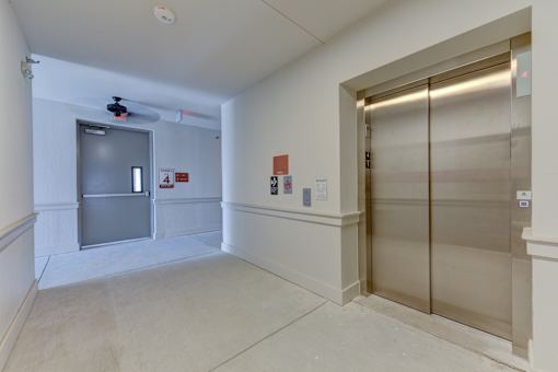 Interior hallway with elevator and stairwell access at Cantarra Apartments, Texas