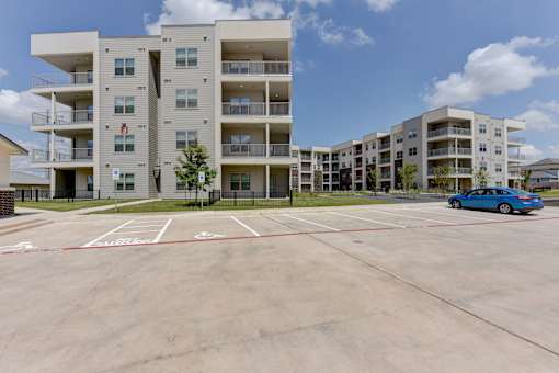 Modern apartment buildings with parking area at Cantarra Apartments, Manor, Texas