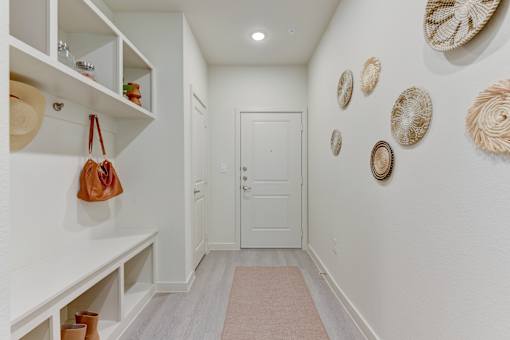 Entryway with built in storage and decorative wall art at Cantarra Apartments, Texas, 78653