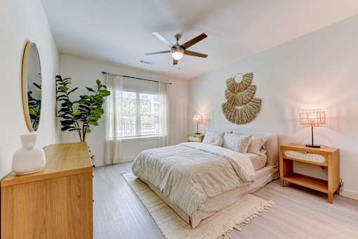 Bedroom with neutral tones and ceiling fan at Cantarra Apartments, Manor, TX 78653
