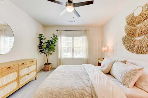 Bedroom with ceiling fan and natural light at Cantarra Apartments, Manor, Texas