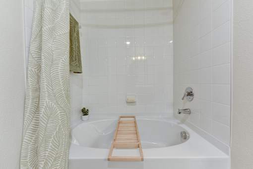 Modern bathroom with soaking tub and white tile at Cantarra Apartments, Manor, TX 78653