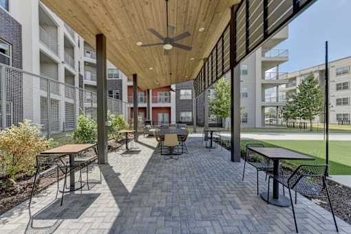Covered outdoor courtyard with seating and wood ceiling at Cantarra Apartments, Manor, 78653