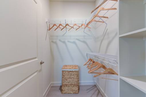 Walk-in closet with wire shelving and hanging rods at Cantarra Apartments, Texas, 78653