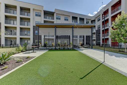 Courtyard with pergola and artificial turf lawn at Cantarra Apartments, Texas