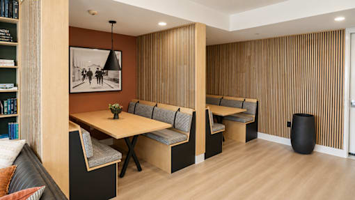 A room with a table and chairs and a picture on the wall.