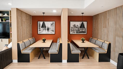 A modern dining room with a long table and chairs.