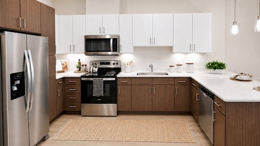 A modern kitchen with a refrigerator, oven, microwave, and sink.