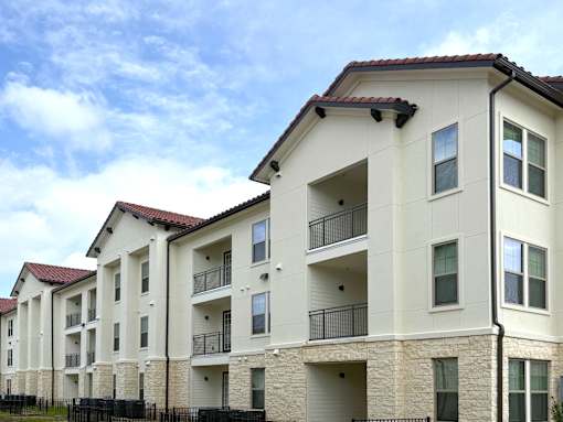 A row of apartment buildings with balconies and doors.