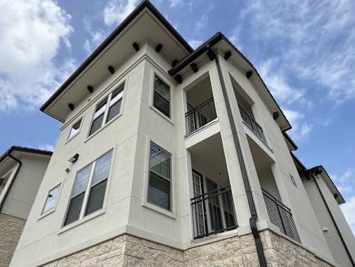A white building with a black roof and windows.